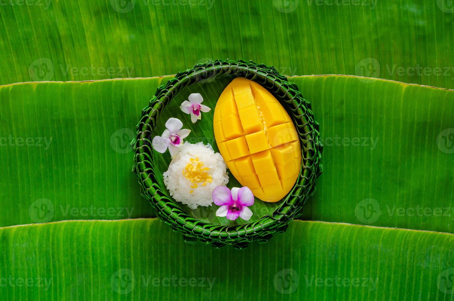 postre tailandés: arroz pegajoso de mango en un plato de hoja de plátano se pone en el fondo de la hoja de plátano. foto