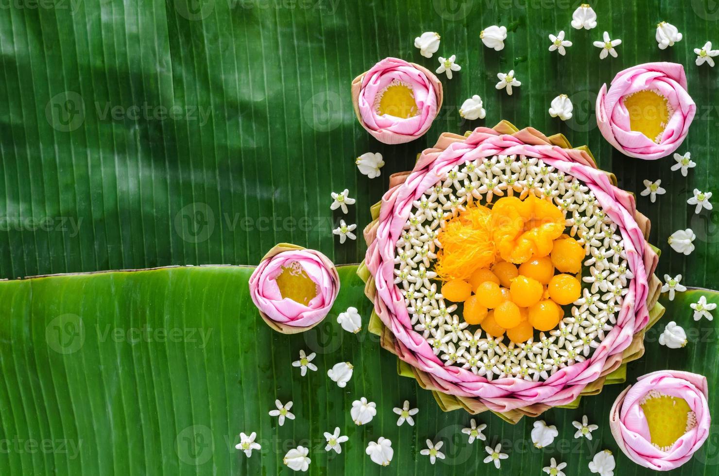 postres de boda tailandeses en plato o krathong hechos de pétalo de loto rosa y flor de corona para la ceremonia tradicional tailandesa sobre fondo de hoja de plátano. foto