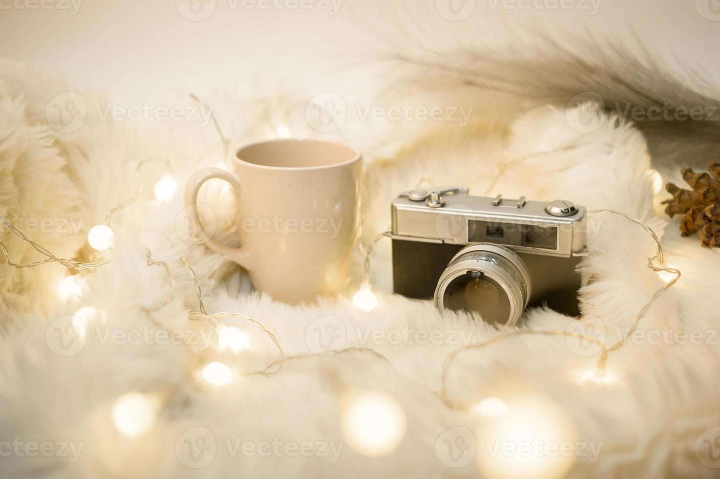 taza de café sobre luces de navidad bokeh en casa en decoraciones de mesa de madera. decoración de vacaciones de invierno, concepto de decoración de navidad y año nuevo foto