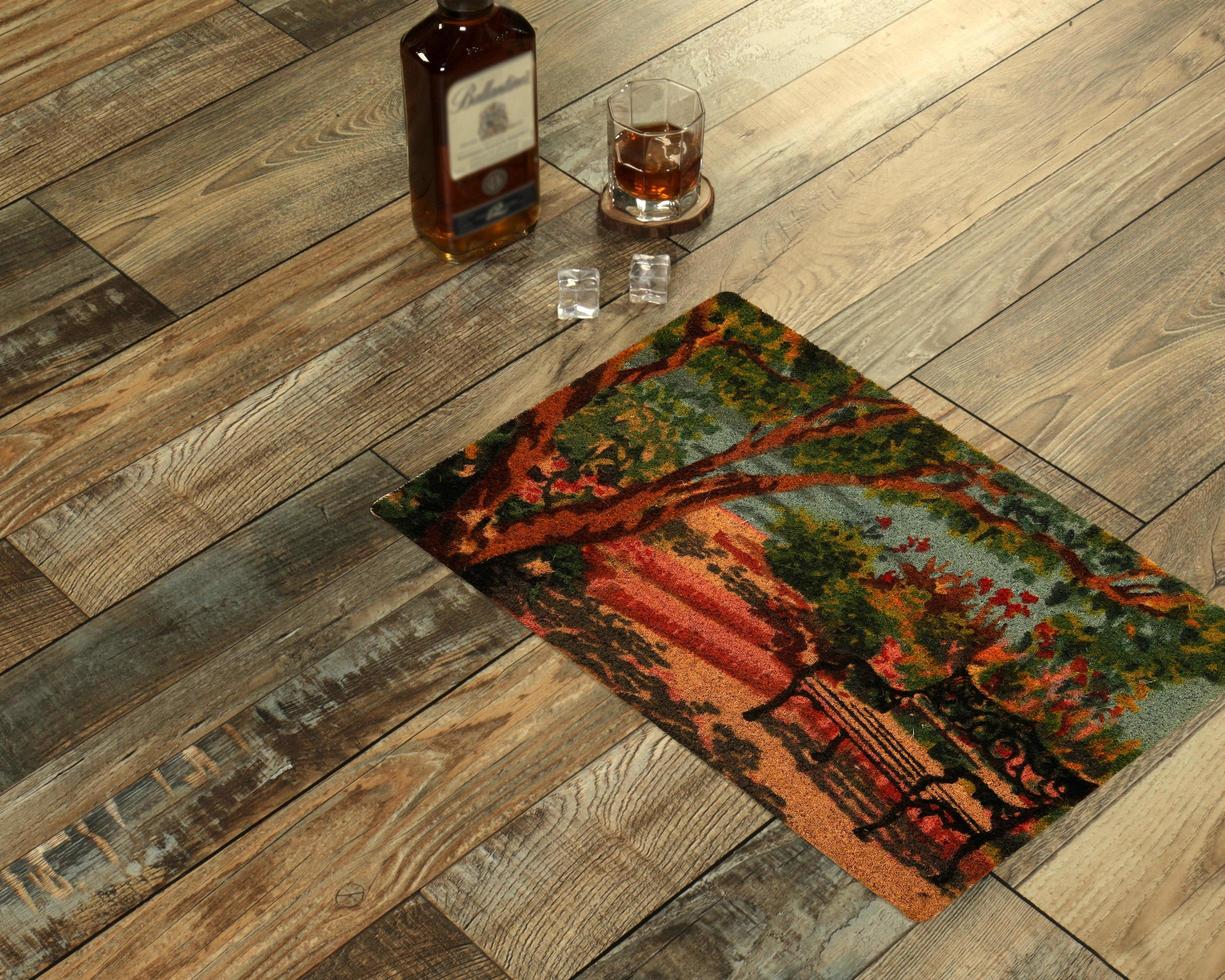 New Delhi, Delhi, IN, 2022 - Modern colorful scenery printed zute doormat with trees placed with Whiskey and Glass photo