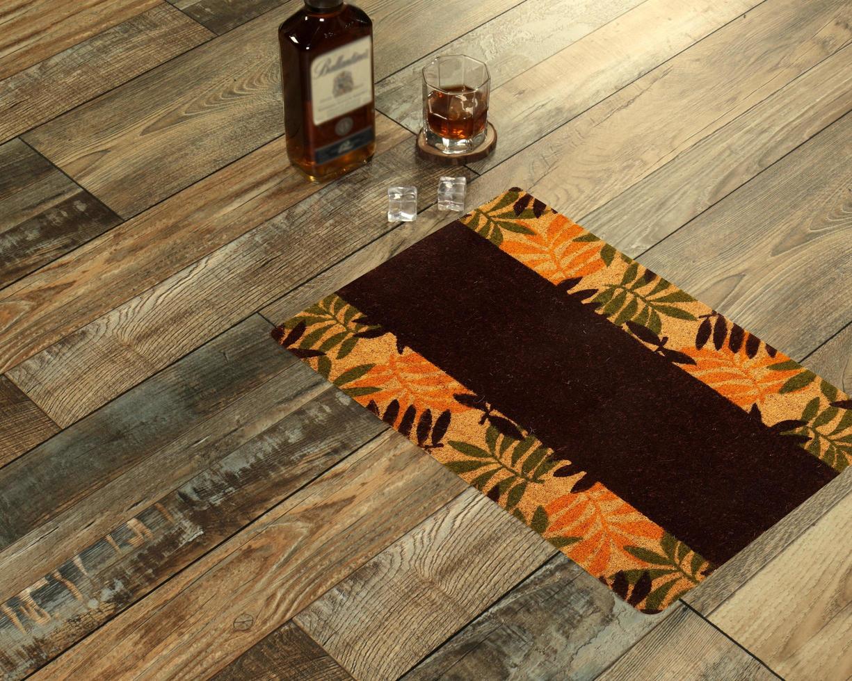New Delhi, Delhi, IN, 2022 - Beautiful Colorful Leaf Printed Welcome zute doormat placed with Whiskey and Glass photo