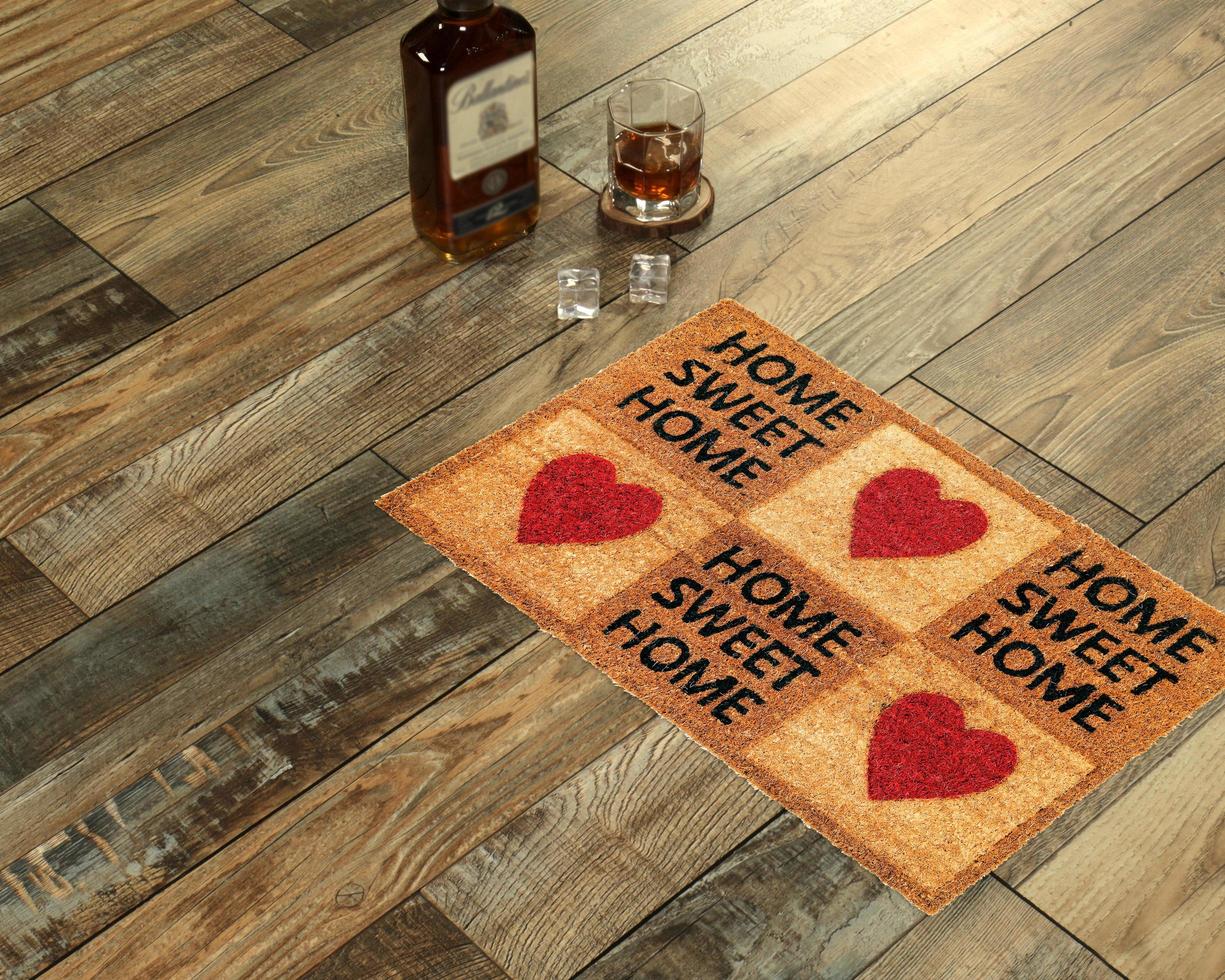 New Delhi, Delhi, IN, 2022 - Beautiful Home sweet home peach color coir doormat with hearts placed with Whiskey and Glass photo