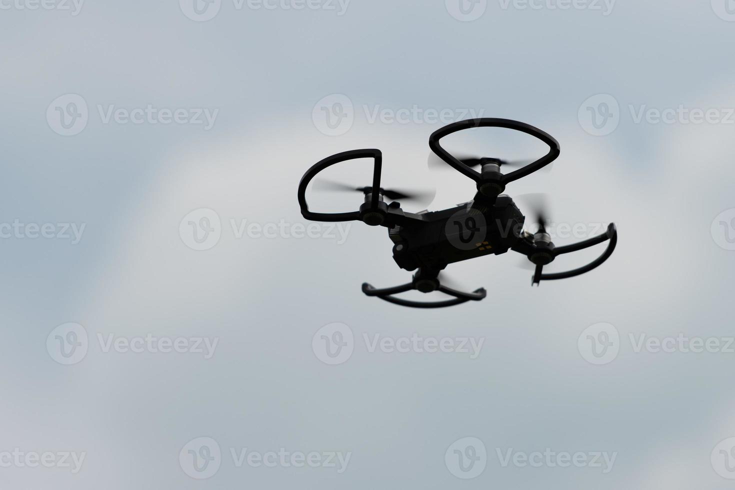 Silhouette of a small drone flying in the sky photo