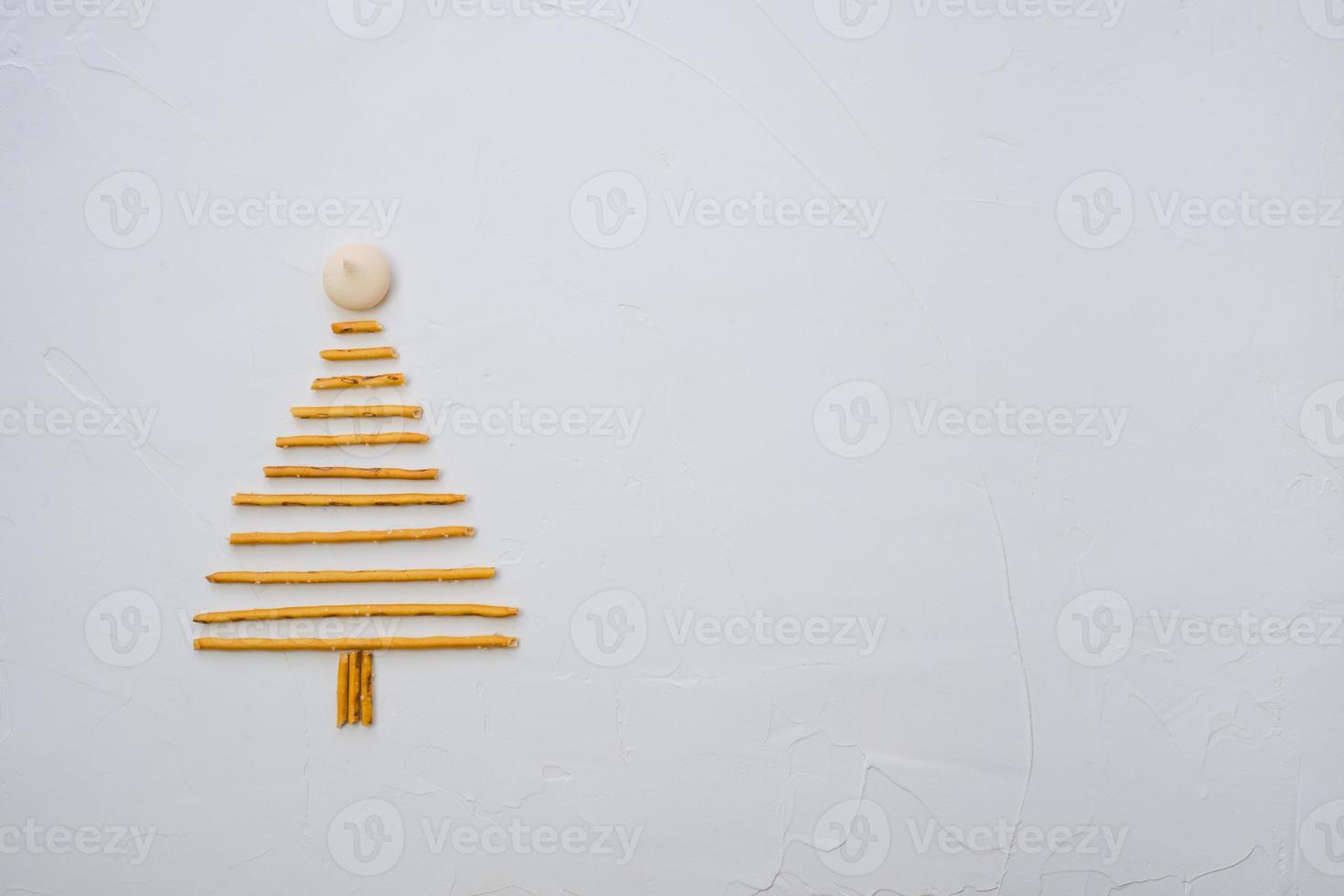 Christmas tree made from pepero straws cookies, on white background texture. Top view with space for text on the right photo