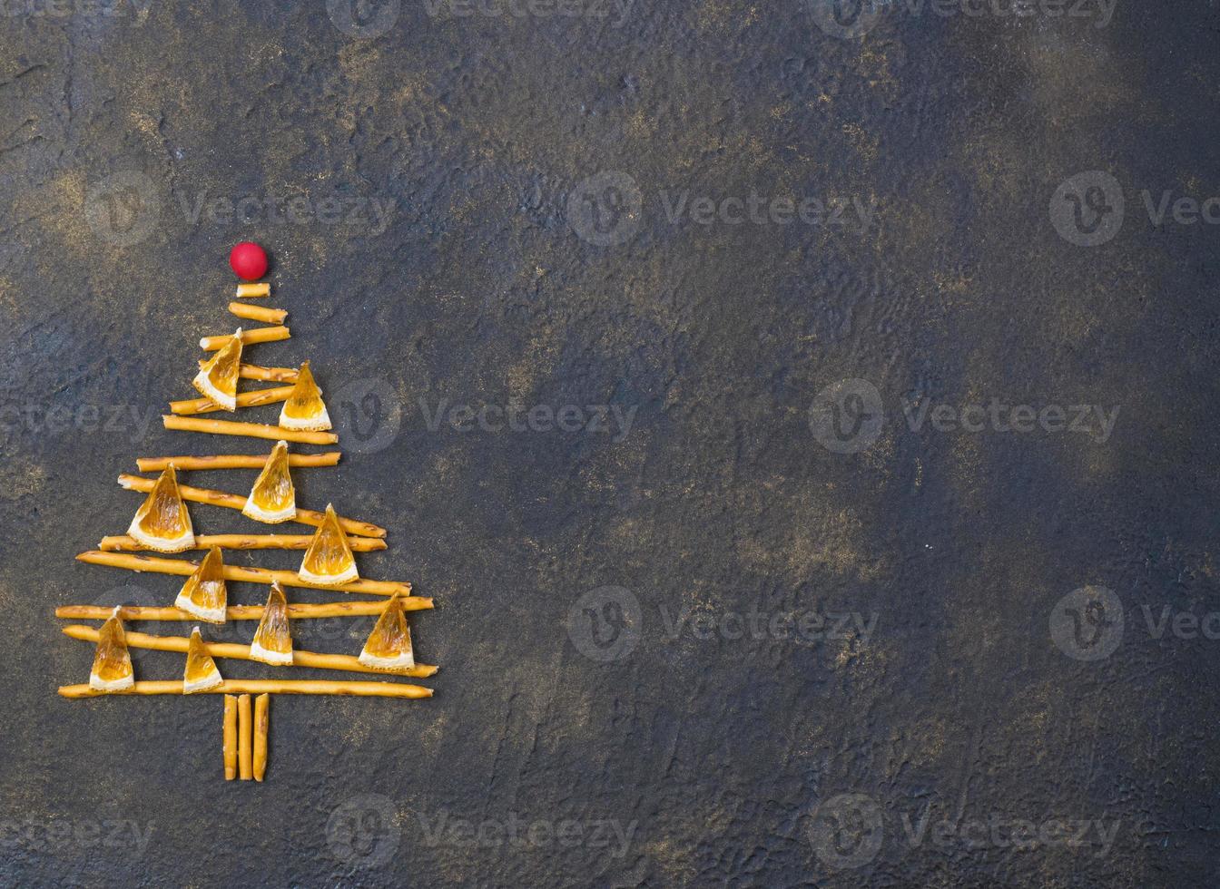 Christmas tree made from pepero straws cookies, on black texture background. View from above. photo