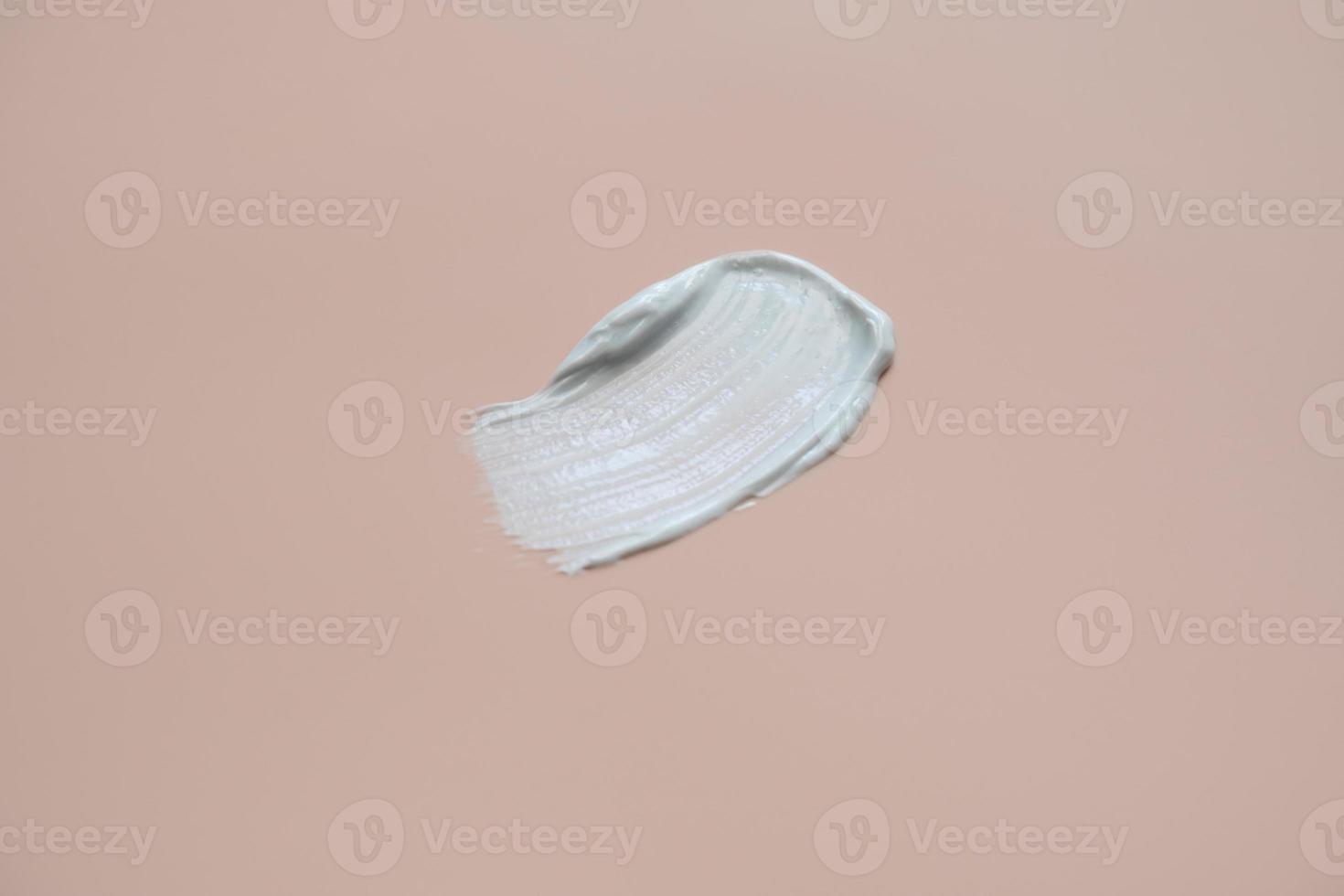 The texture of white delicate cream on a beige background. photo