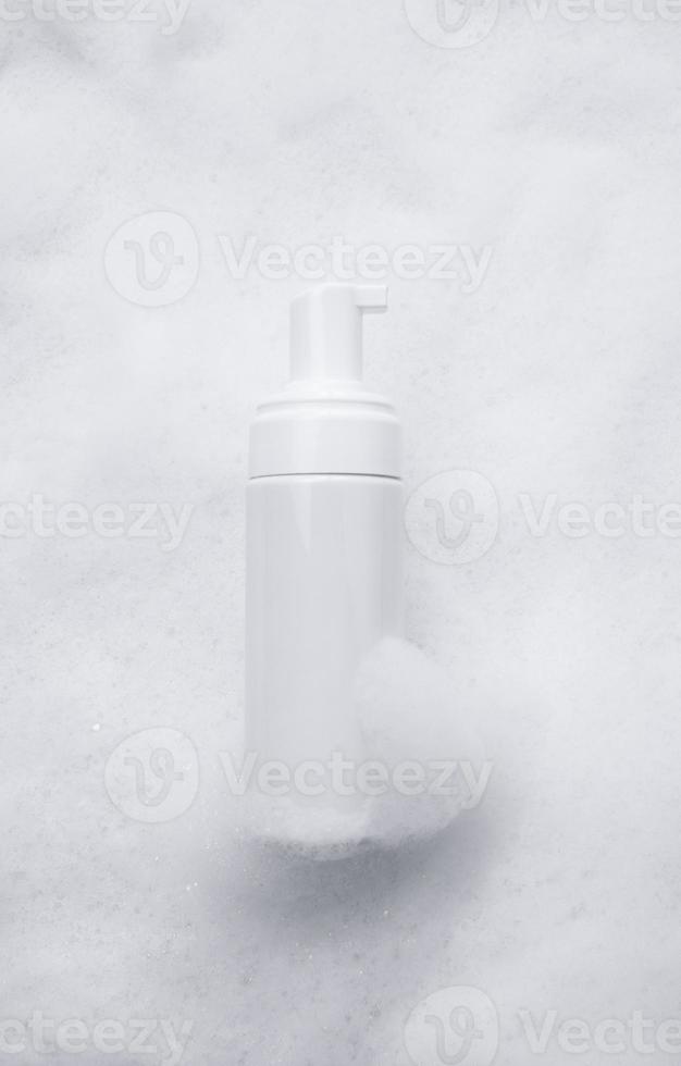 White plastic tube mockup with moisturizer cream, shampoo or facial cleanser and gentle soap foam with bubbles on marble background, top view. Treatment spa beauty skincare cosmetic product photo