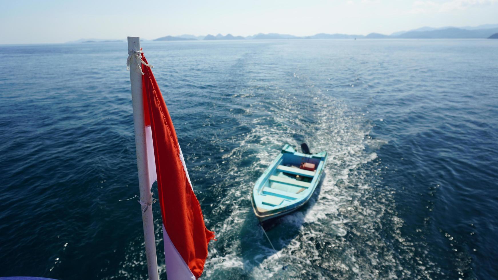 Boat tagged behind sail boat photo