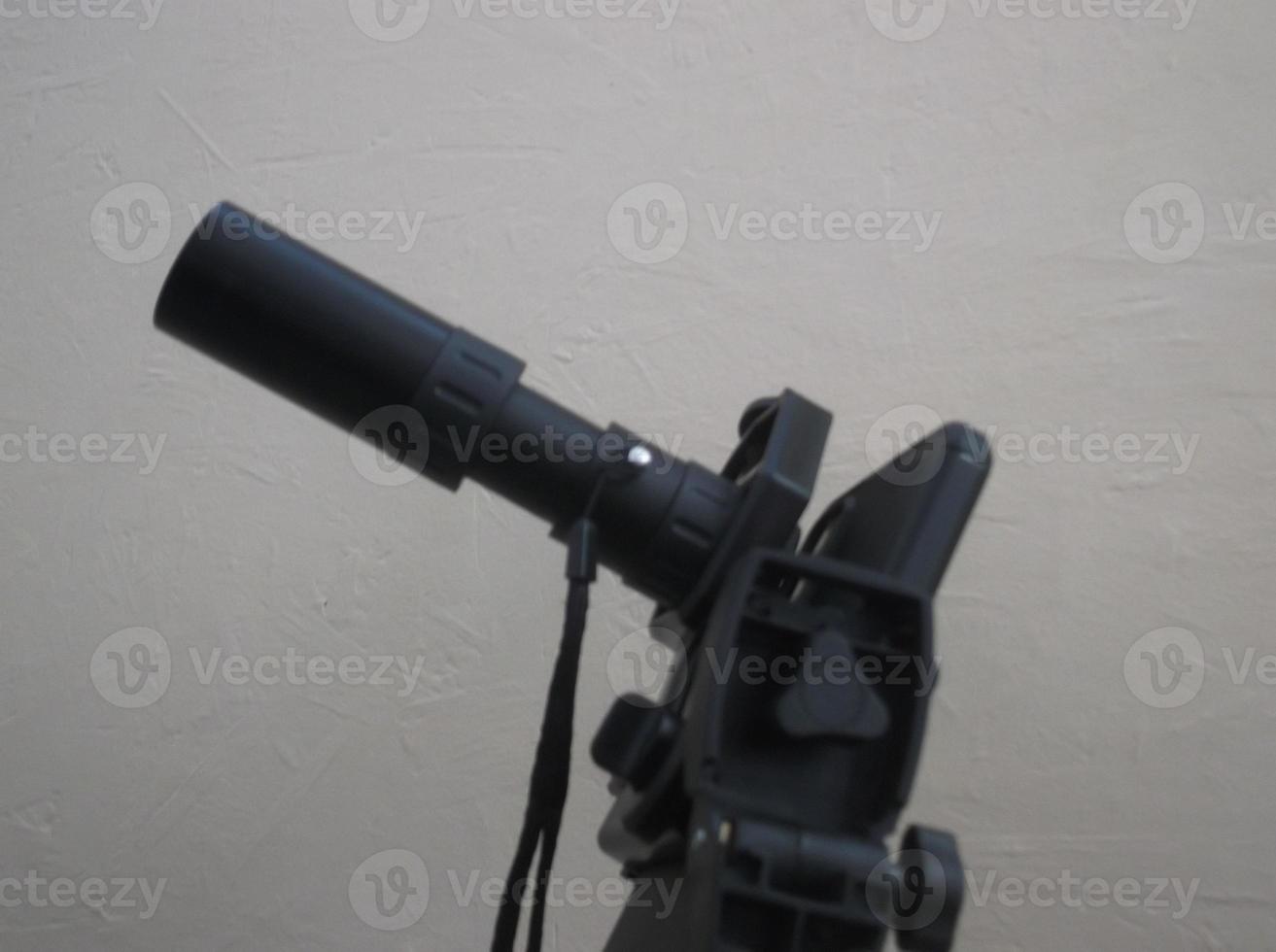 Attachment between monocular telescope and smartphone on a tripod photo