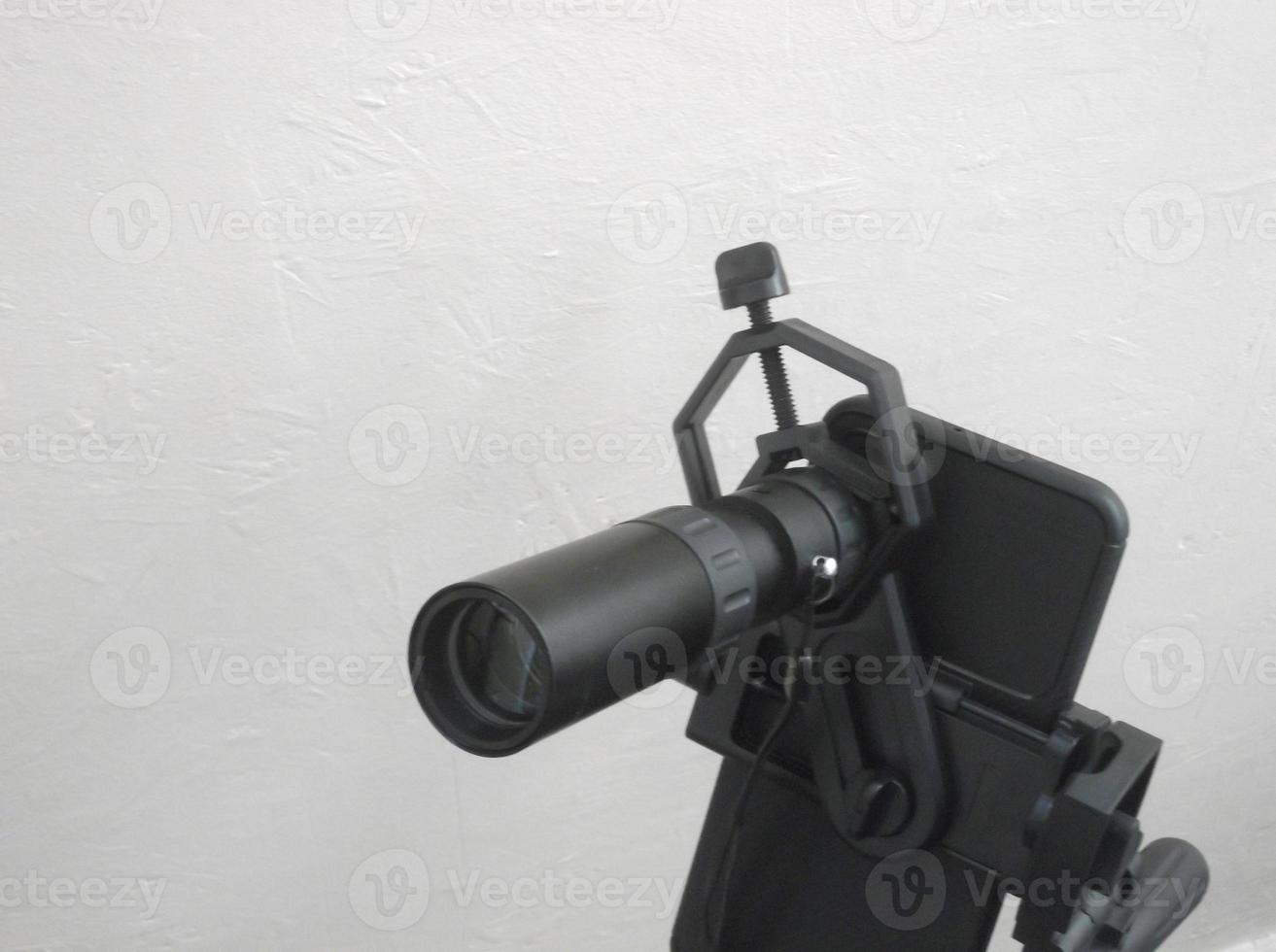 Attachment between monocular telescope and smartphone on a tripod photo