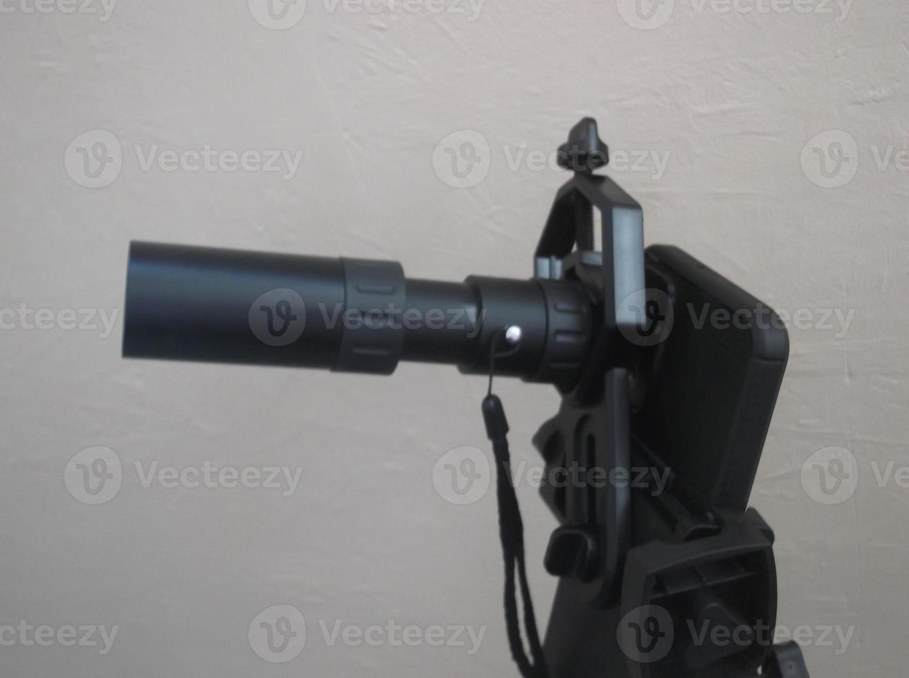 Attachment between monocular telescope and smartphone on a tripod photo