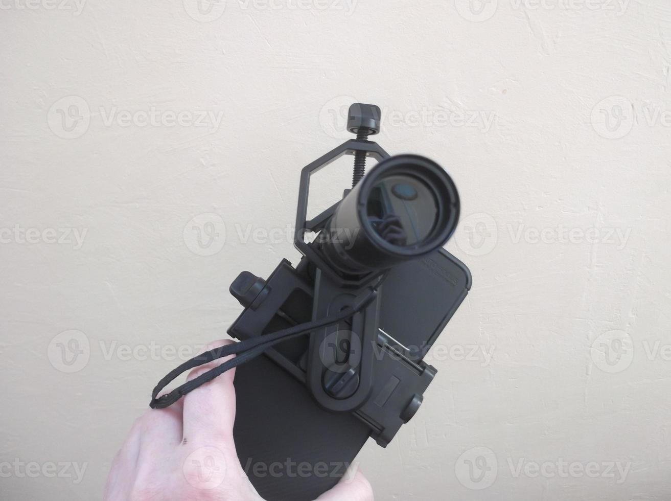 Attachment between monocular telescope and smartphone on a tripod photo