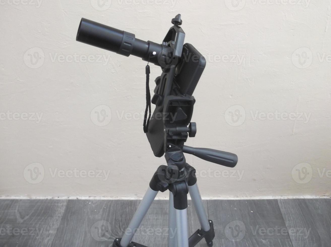 Attachment between monocular telescope and smartphone on a tripod photo