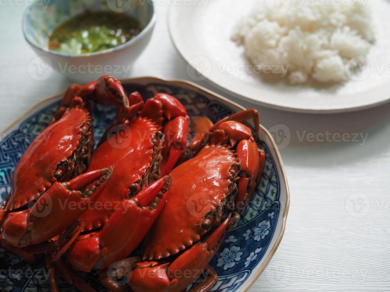 Stream sea crab with jasmine white rice and spicy seafood sauce in Thai style on a white table photo