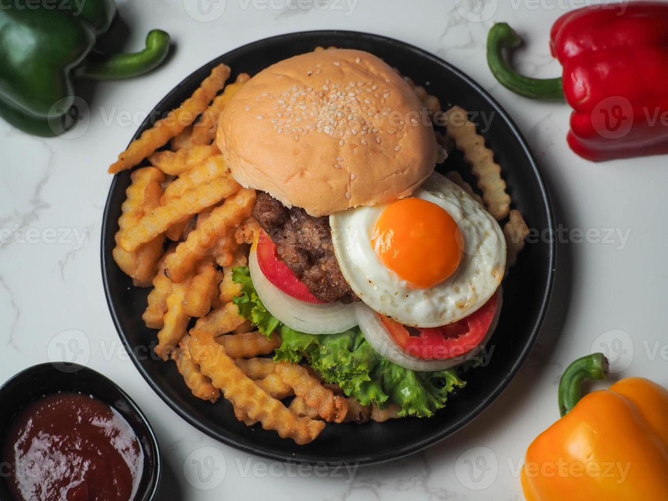 Homemade pork hamburger with fresh lettuce, tomato, fried egg, fresh onion photo