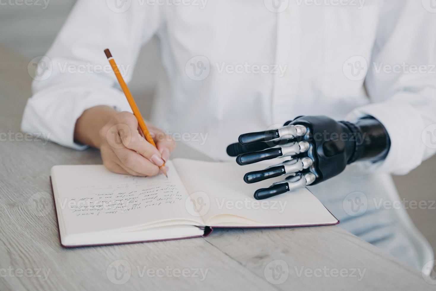 Female makes notes writes in diary, holds notebook using robotic hand. Bionic prosthesis advertising photo