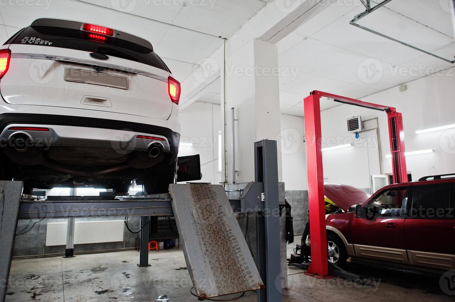 American SUV car on stand for wheels alignment camber check in workshop of service station. photo