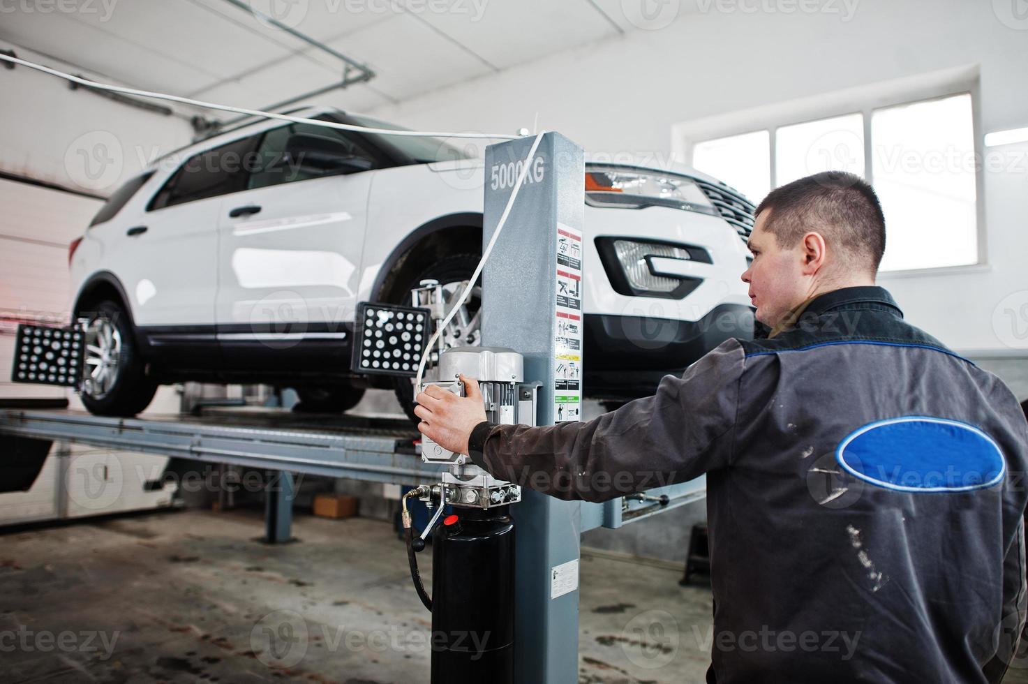 El mecánico de automóviles establece un automóvil suv americano para el diagnóstico y la verificación de la inclinación de la configuración en el taller de la estación de servicio. foto