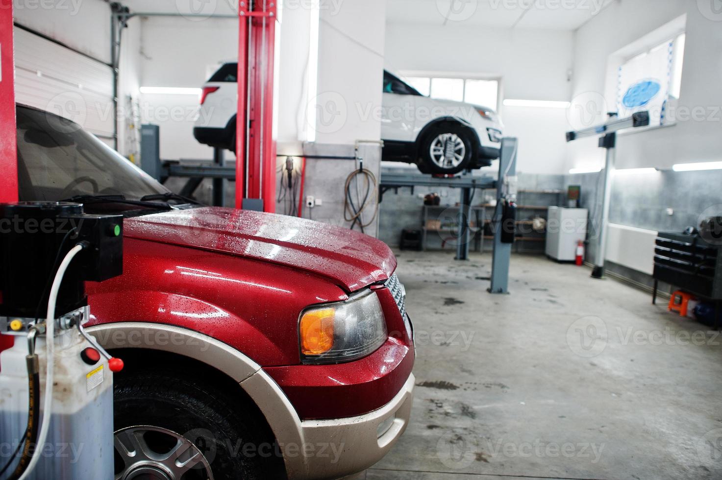Two american SUV car on stand for wheels alignment camber check in workshop of service station. photo