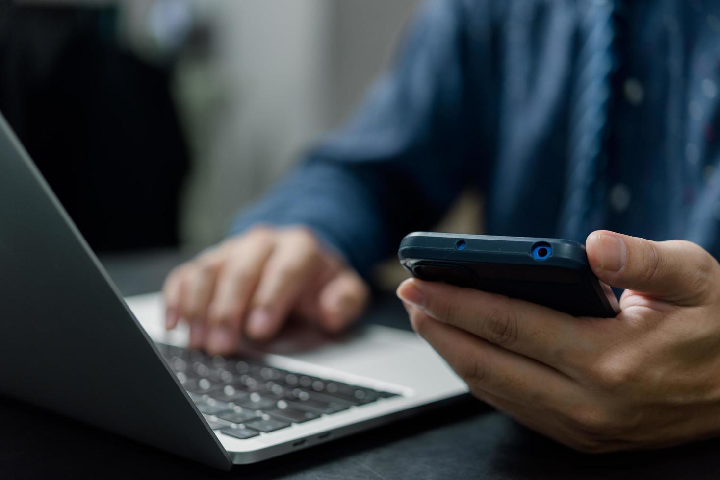 mano de hombre sosteniendo comunicaciones de red de tecnología digital de teléfono inteligente móvil en el escritorio. foto