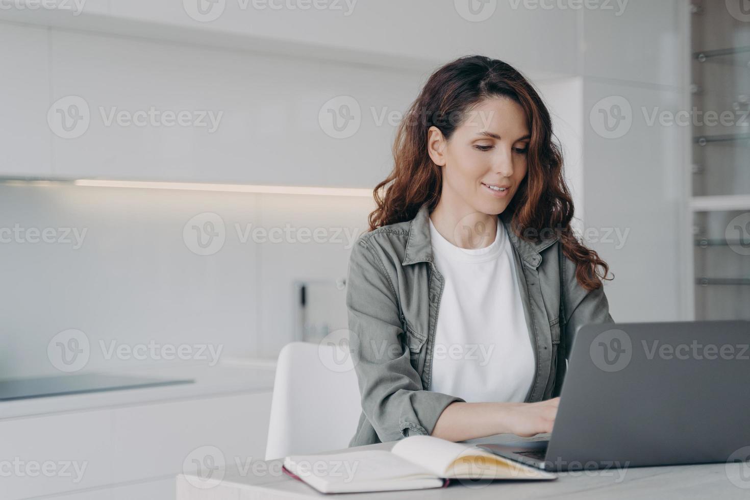 Hispanic woman working or learning online at laptop at home. Remote job or education, elearning photo