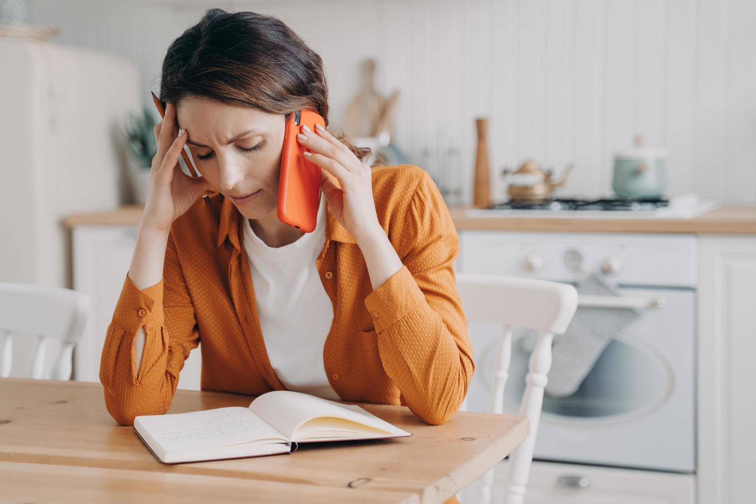 Female calling customer service, solving domestic problems by phone, hearing bad news in kitchen photo