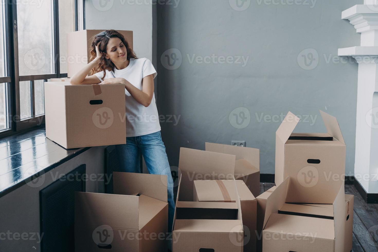 Female dreaming about new home on moving day standing with a lot of