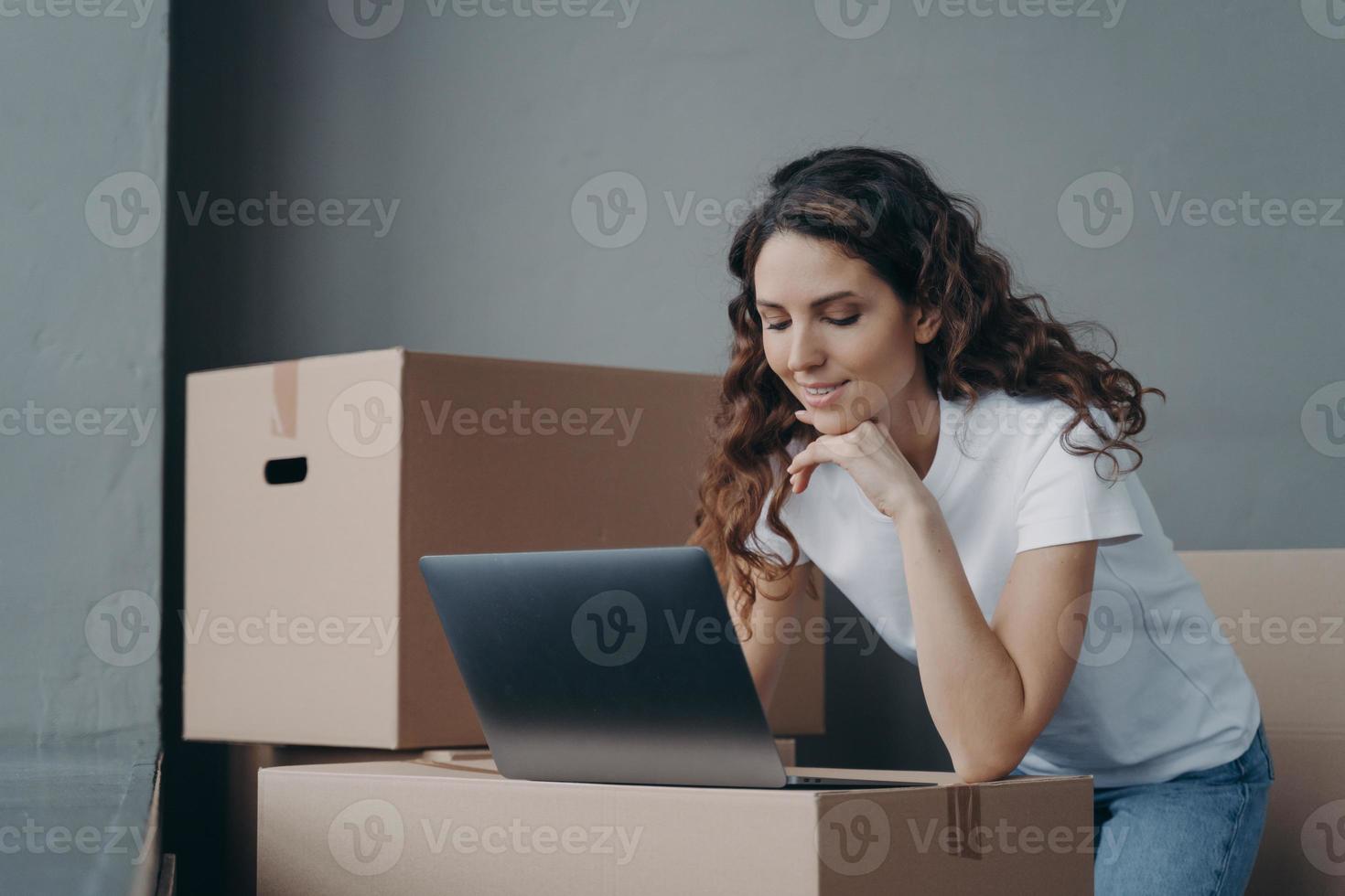 la mujer de negocios trabaja en la computadora portátil y prepara los pedidos de la tienda en línea para enviarlos. pequeña empresa, comercio electrónico foto