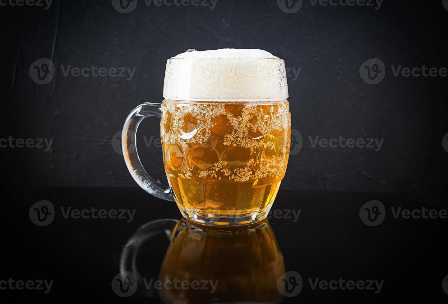 Mug of light beer on dark background. Craft unfiltered beer photo