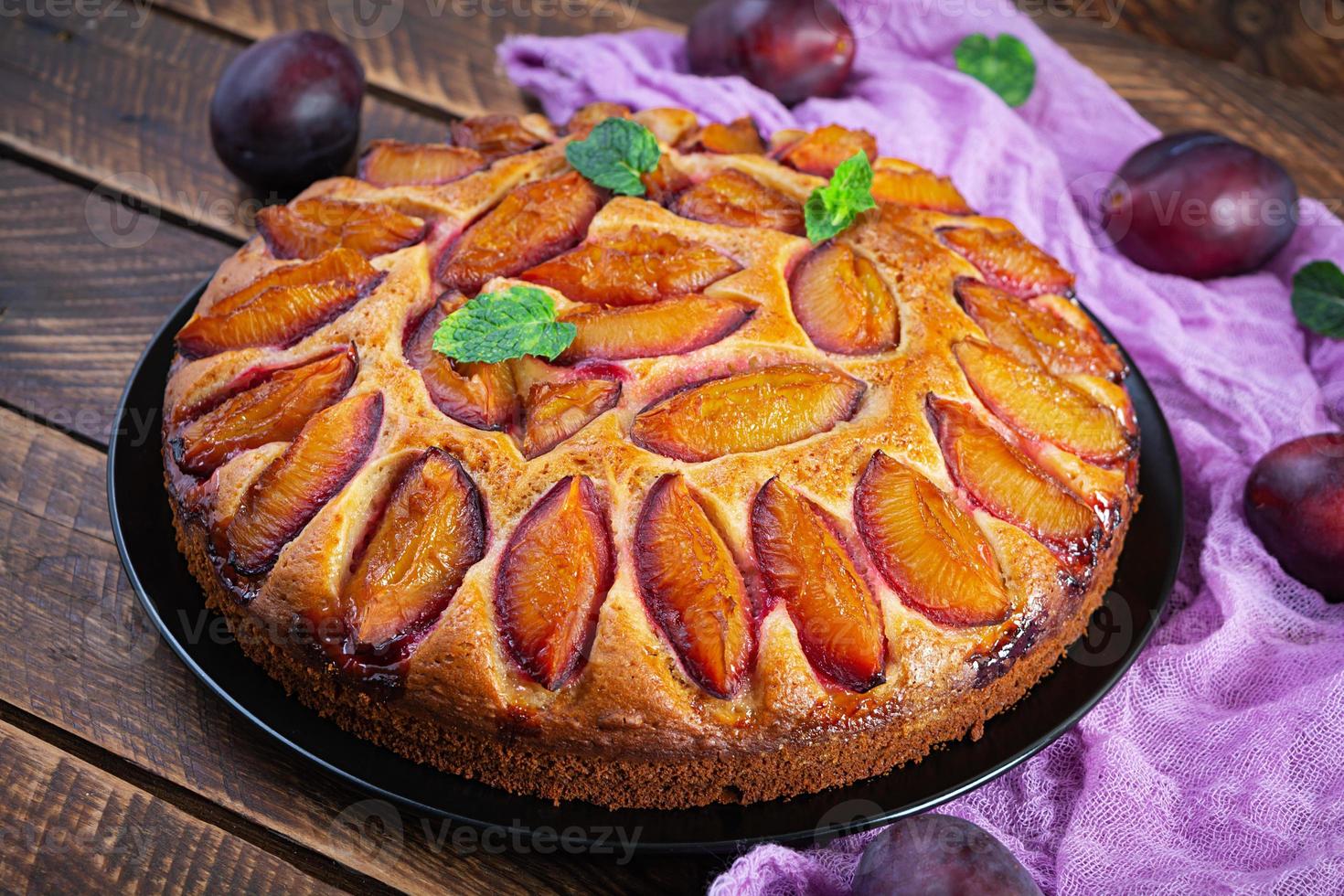 Delicious plum cake on wooden background. Homemade plum pie photo