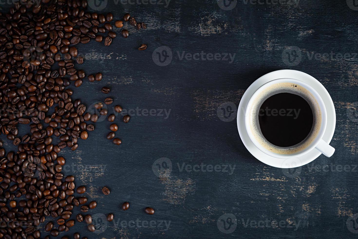 Cup of coffee with coffee beans on dark background. Mug of hot drink coffee photo