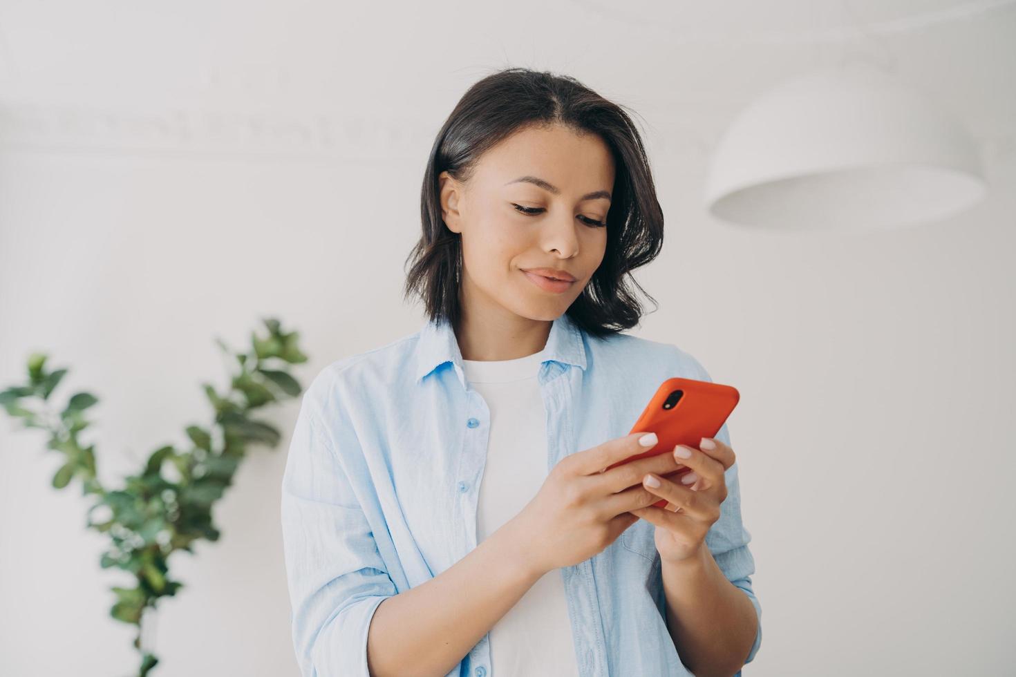 mujer sosteniendo un teléfono inteligente, usando aplicaciones móviles, leyendo mensajes, comprando en una tienda en línea. comercio electrónico foto