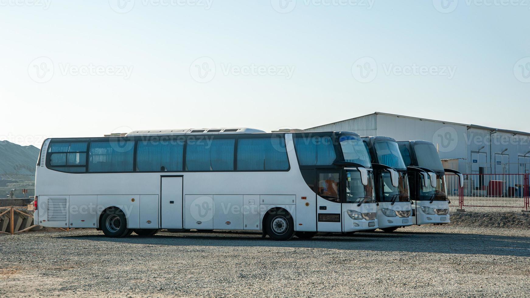 los autobuses de un turno de pasajeros se paran en una fila en un sitio de construcción foto