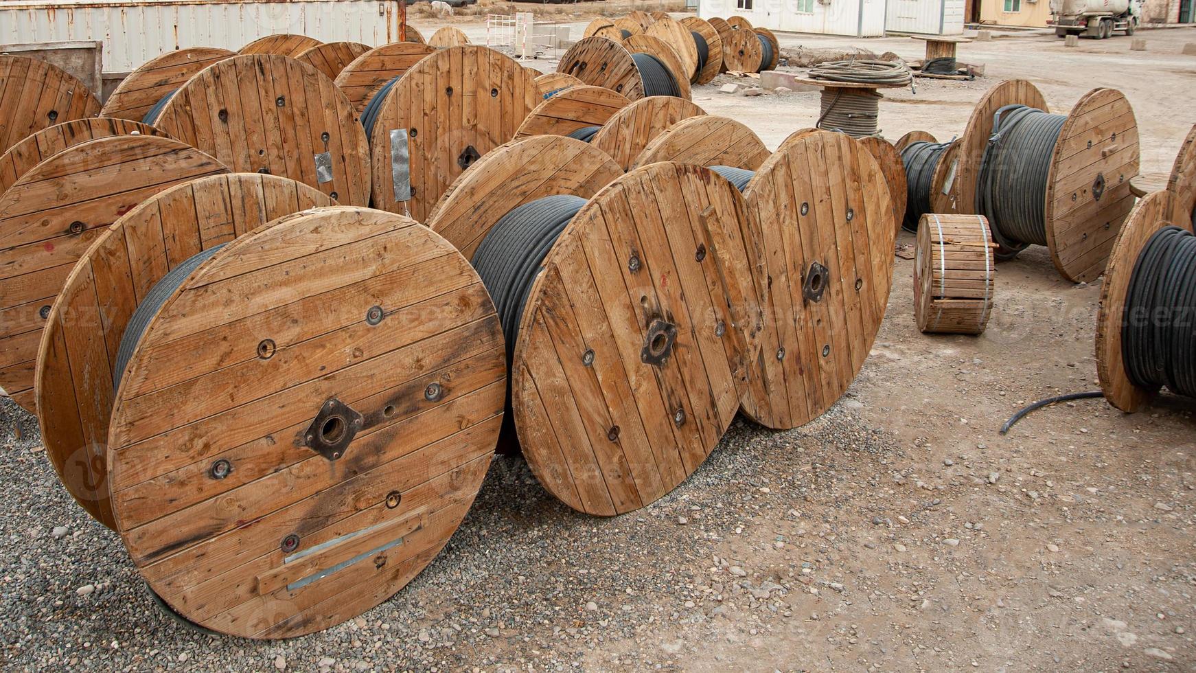 A closeup of large industrial wooden bobbins with cable on a construction site photo