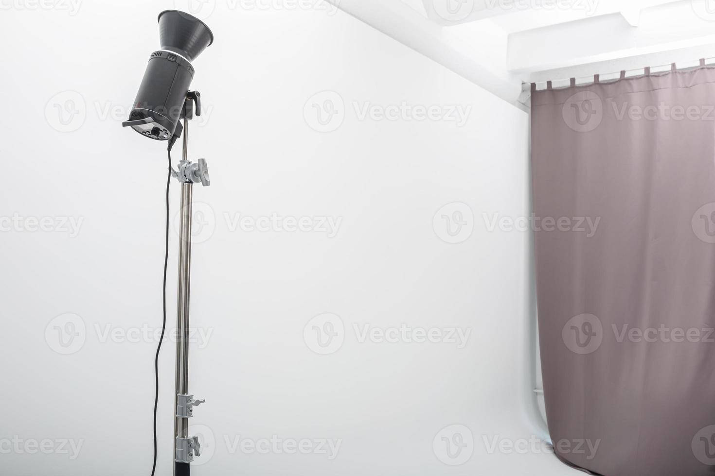 interior of bright space of photo studio with large white cyclorama with lighting equipment