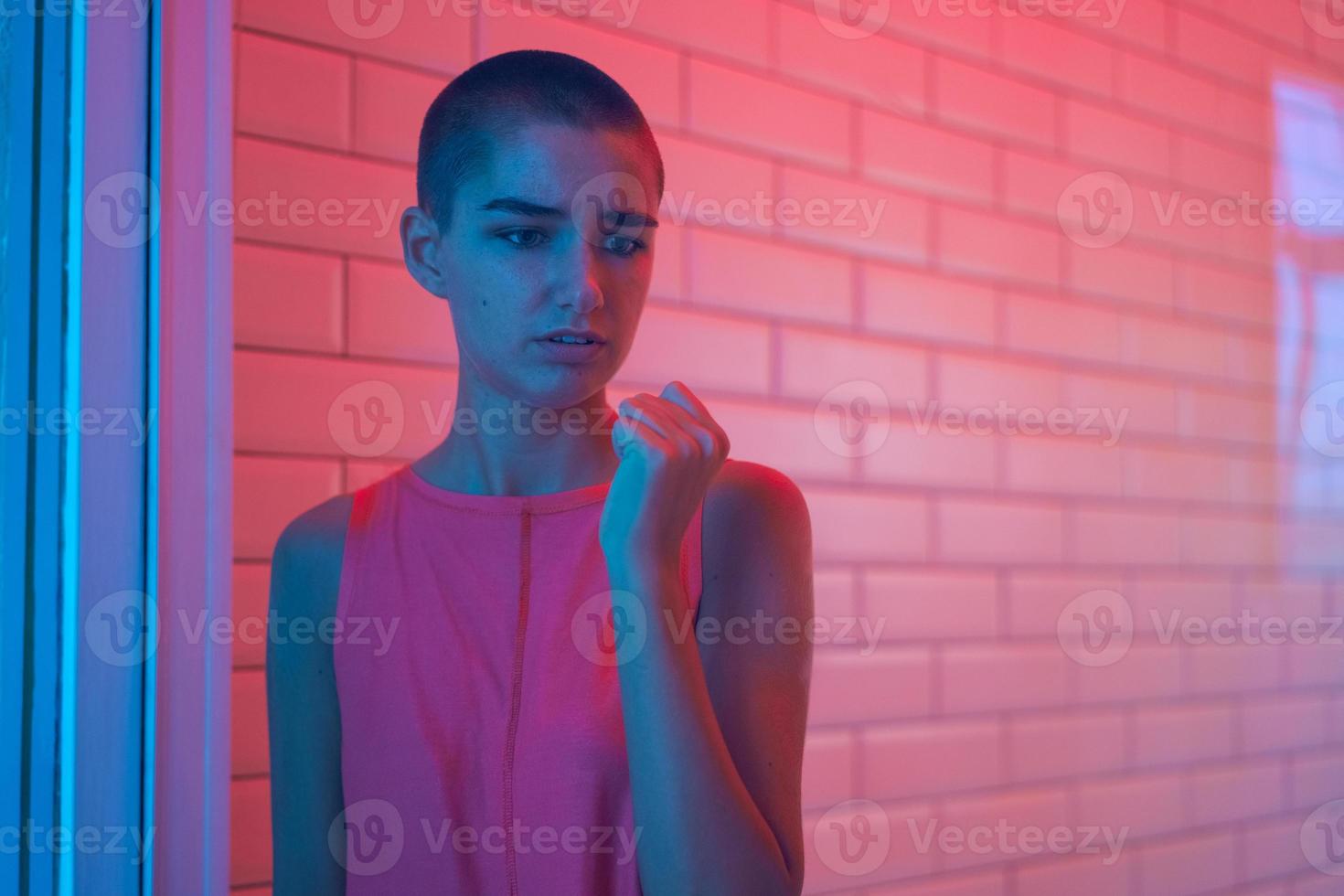 Lonely sad teenager girl student knocking on window in frustration, sad young photo