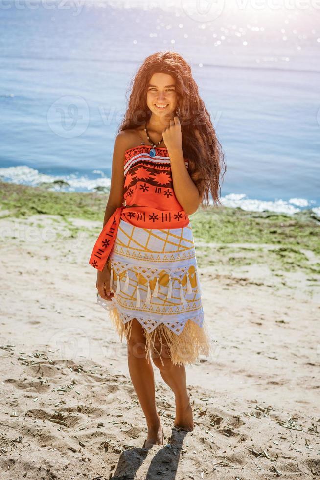 girl walks on the beach, posing against the background of the sea photo