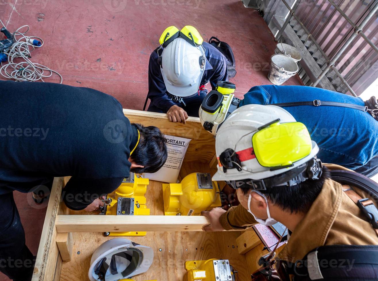 The man turning the padlock code to unlock the mechanical shutter of the radioactive instrument holder photo