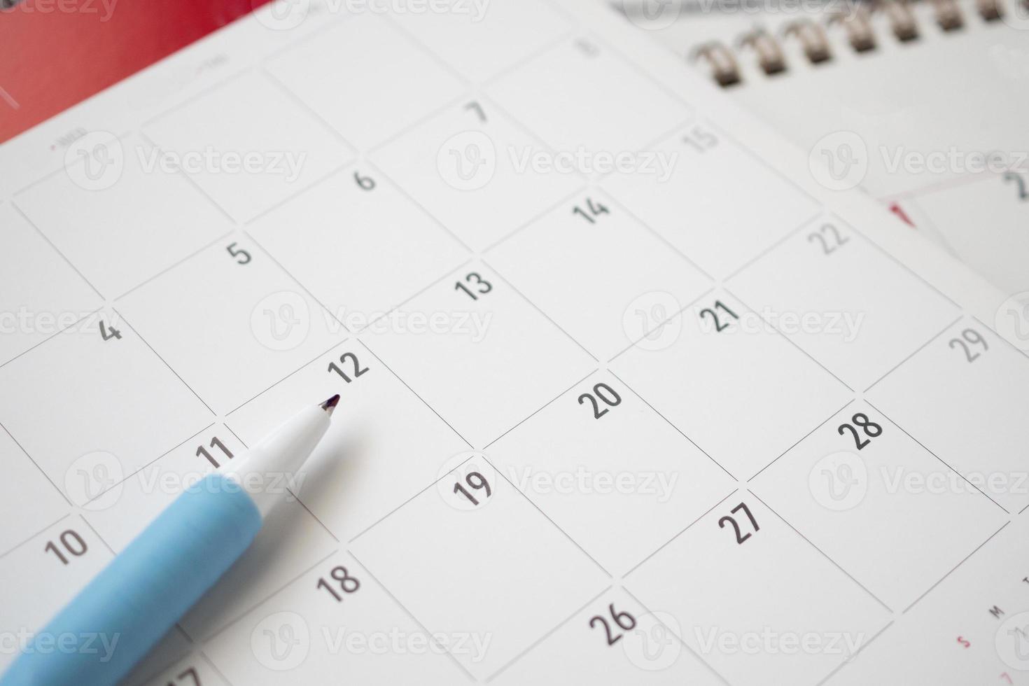 calendar page with pen close up on blue background business planning appointment meeting concept photo