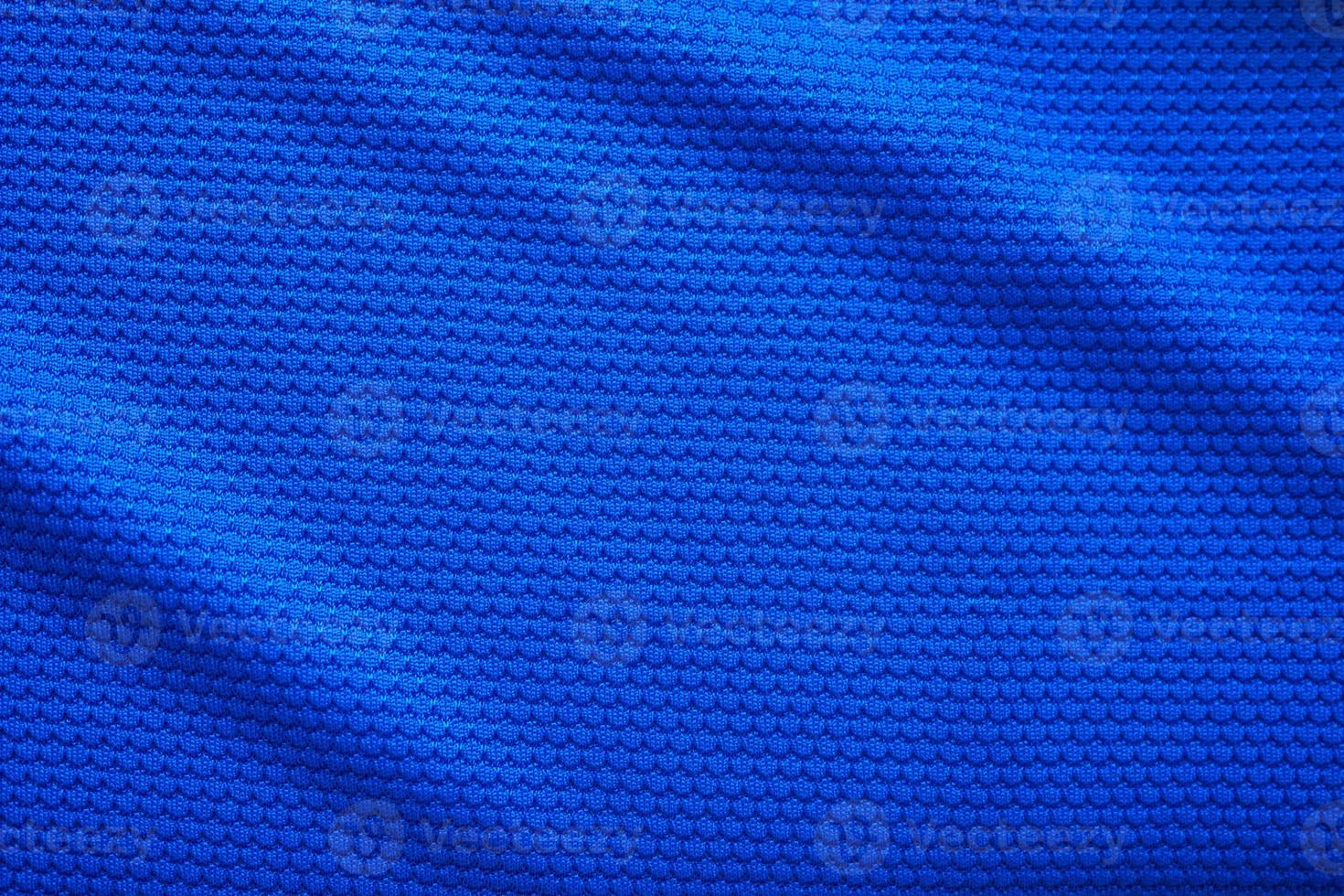 Blue football jersey clothing fabric texture sports wear background, close up top view photo