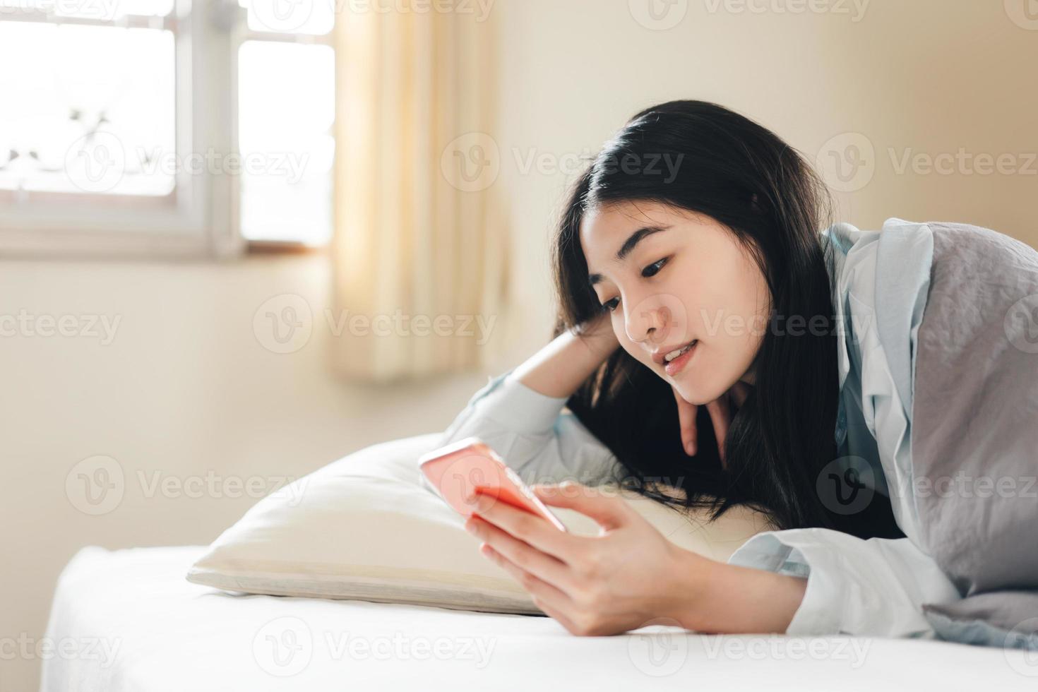 mujer adulta joven soltera que usa un teléfono inteligente por la mañana para chatear con un amigo en la aplicación de mensajes sociales foto