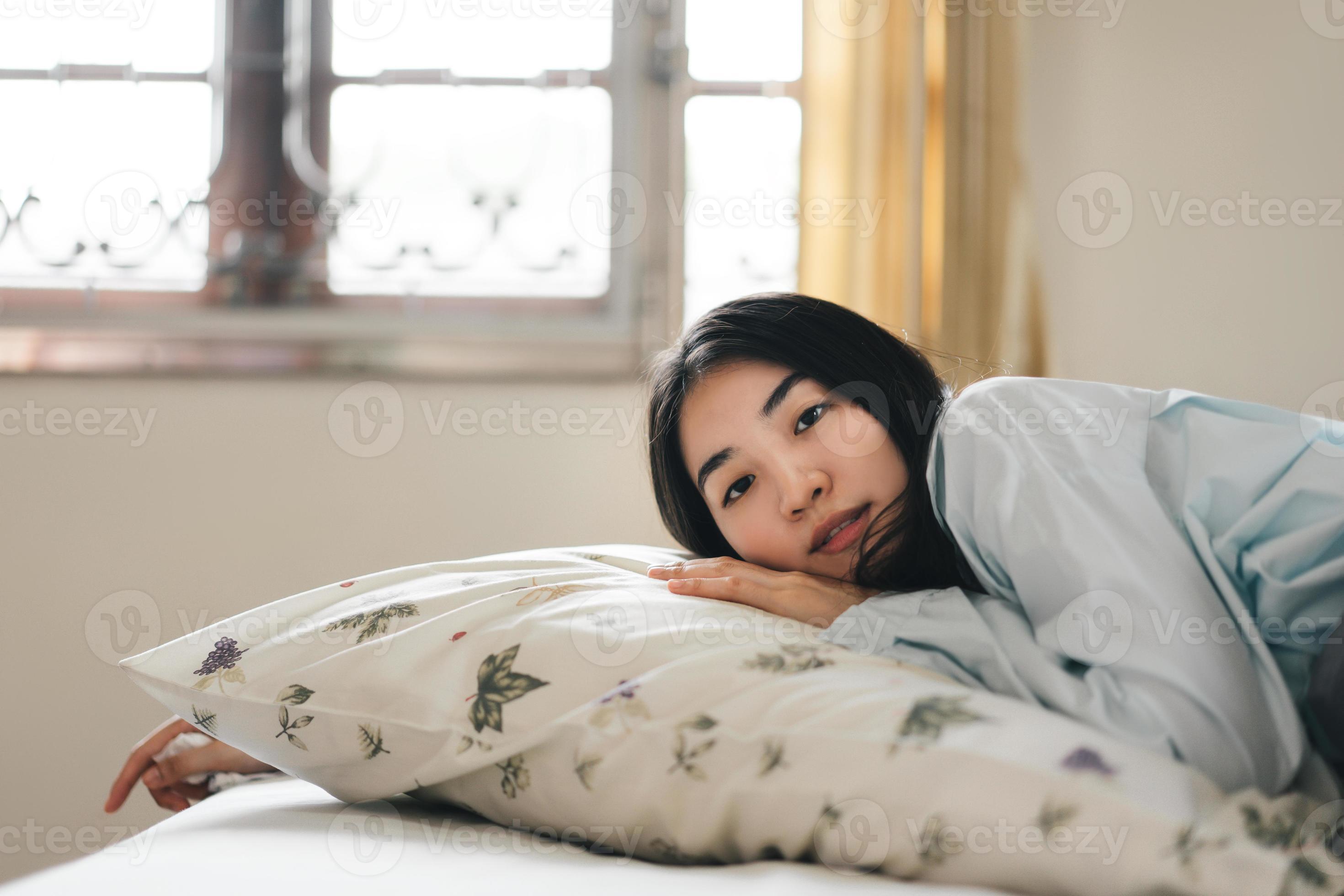 Eye contact with young adult asian woman sleep in bedroom on morning