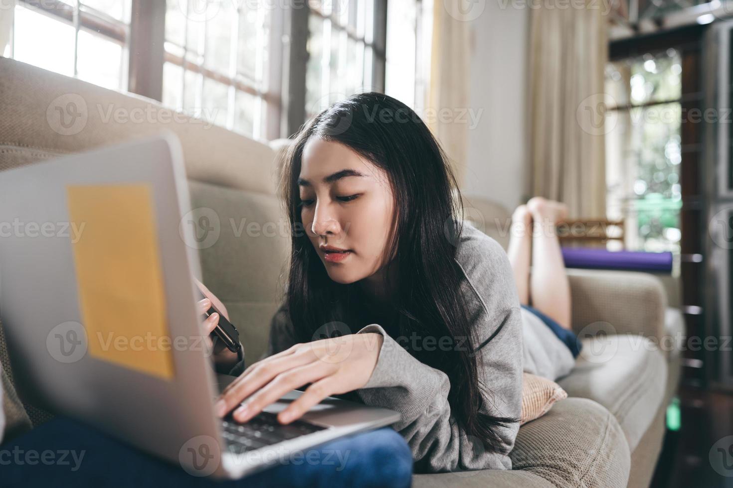 Young adult lonely single woman using laptop and smartphone in the moring for social message app chat with friend for mental health. photo