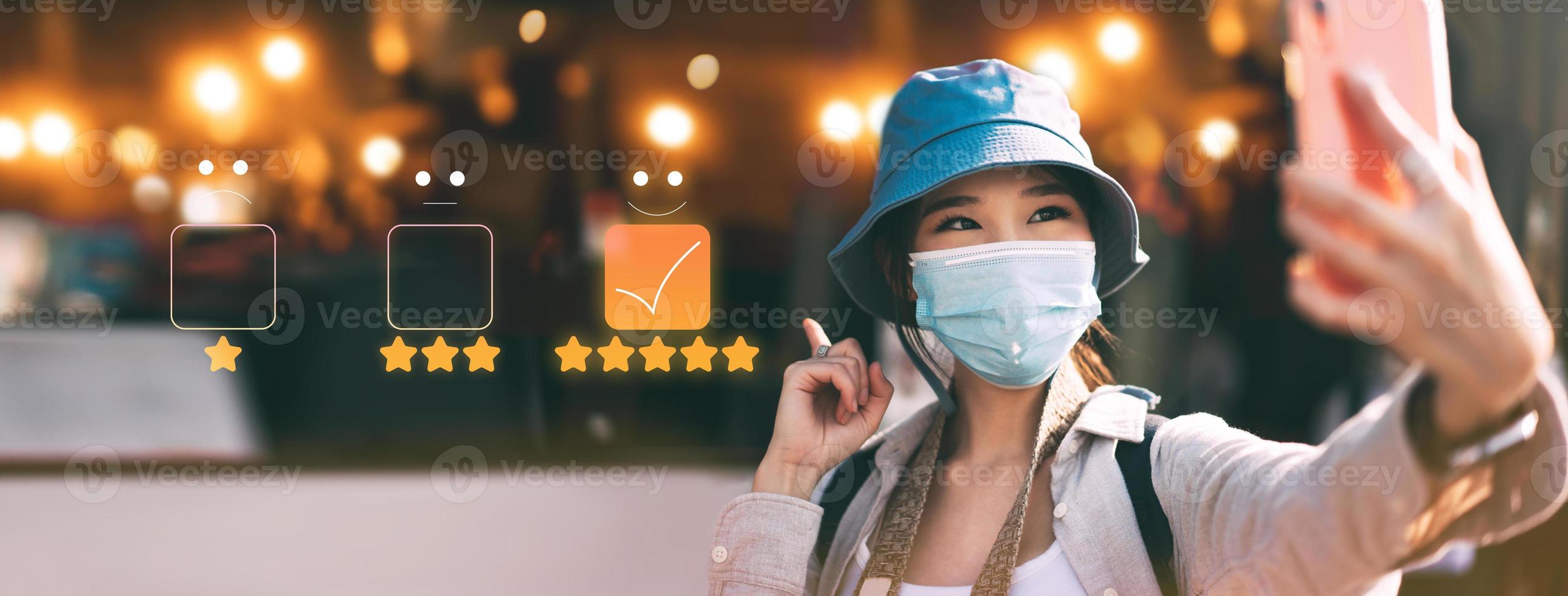 Young adult asian woman travel wear face mask in customer review rating five star service photo
