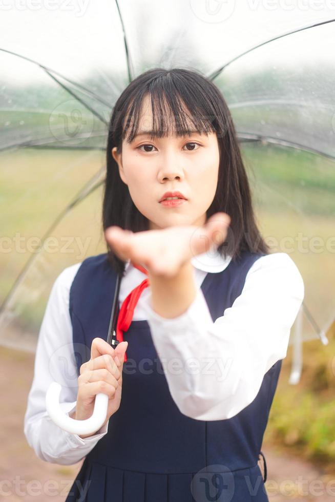 Portrait of cosplay young woman short hair wear japanese student high school uniform with umbrella photo