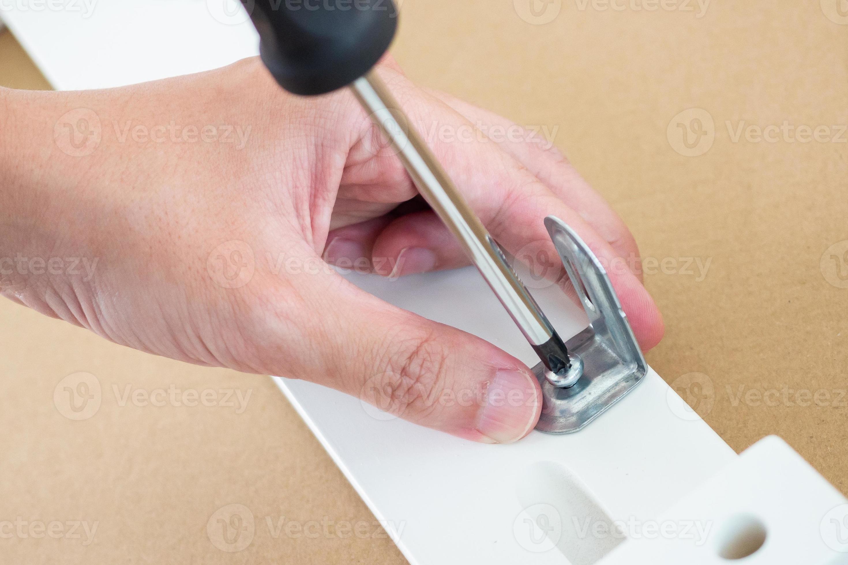 Assembly furniture using screwdriver at home 12971260 Stock Photo at
