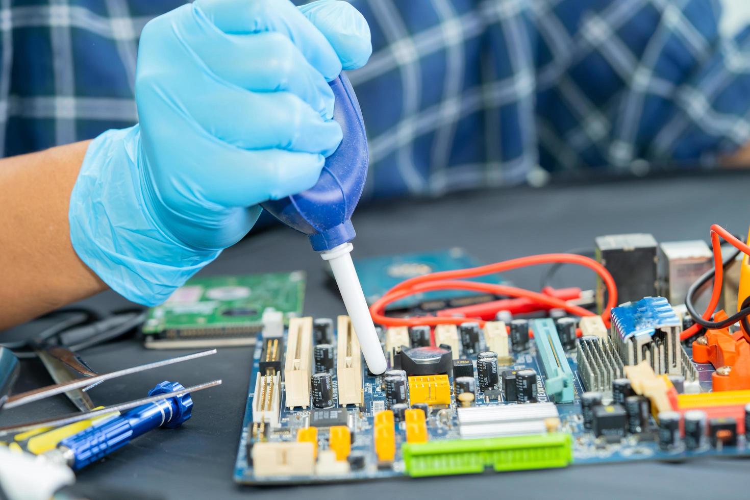 Technician use air blower ball to clean dust in circuit board computer. Repair upgrade and maintenance technology. photo