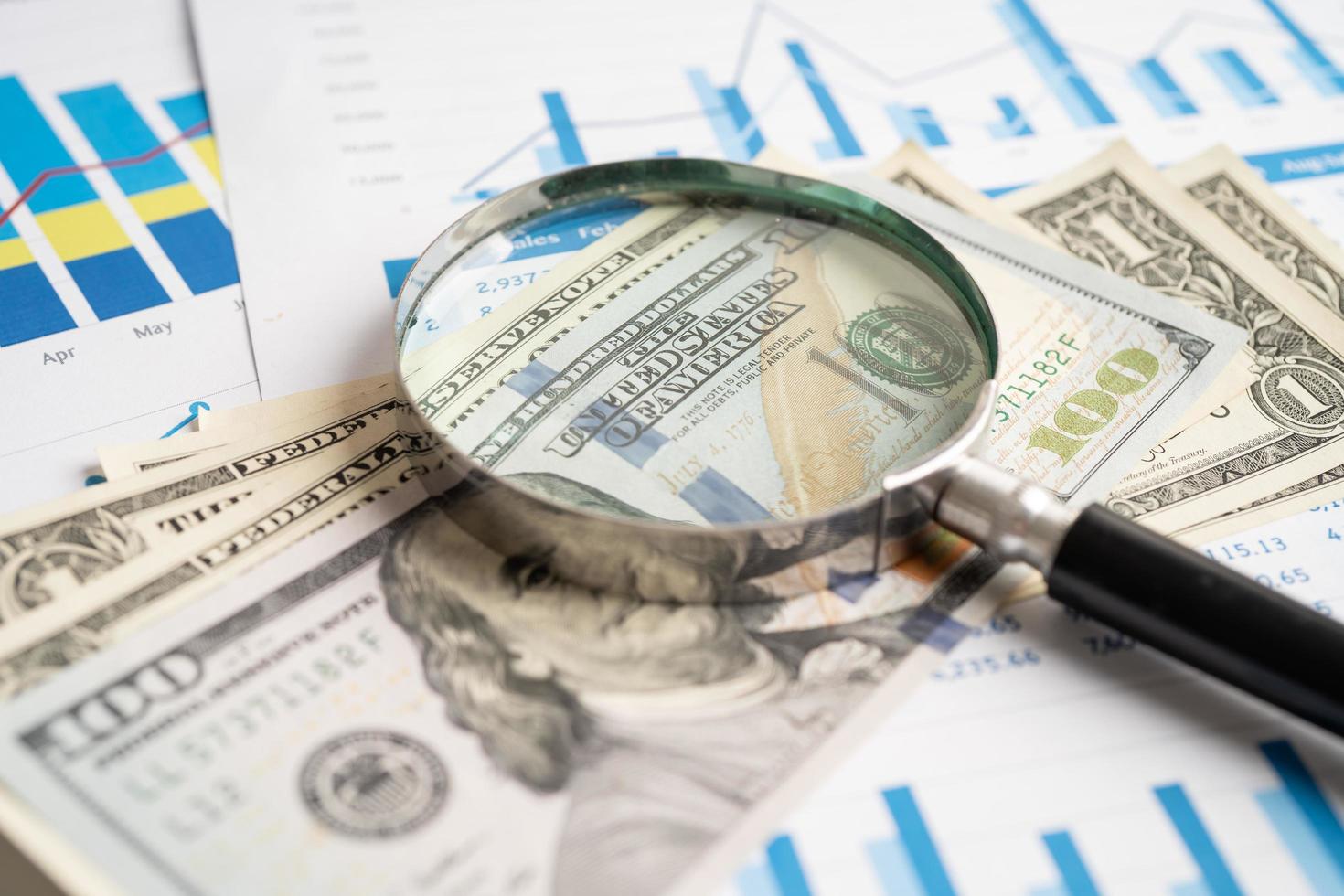 Magnifying glass with US dollar banknotes on charts graphs paper. Financial development, Banking Account, Statistics, Investment Analytic research data economy. photo