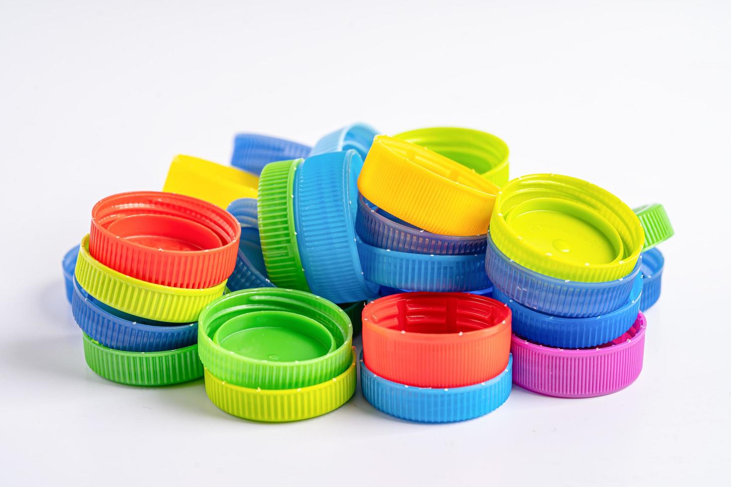 Plastic bottle colored screw caps for recycle waste on white background, container water lid. photo