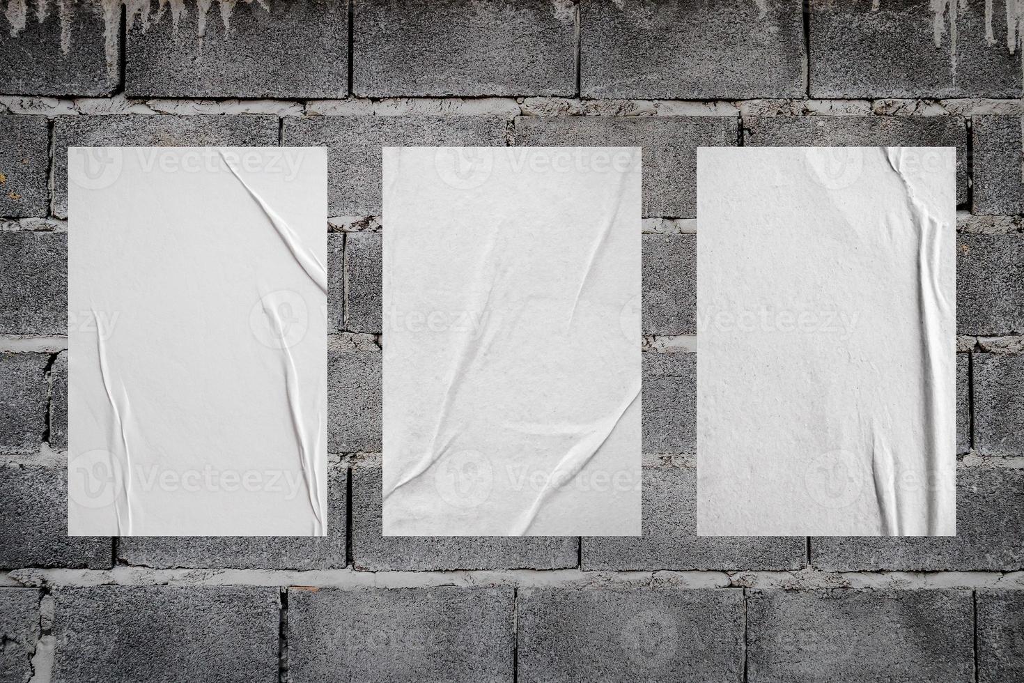 Blank white wheatpaste glued paper poster mockup on concrete wall background photo